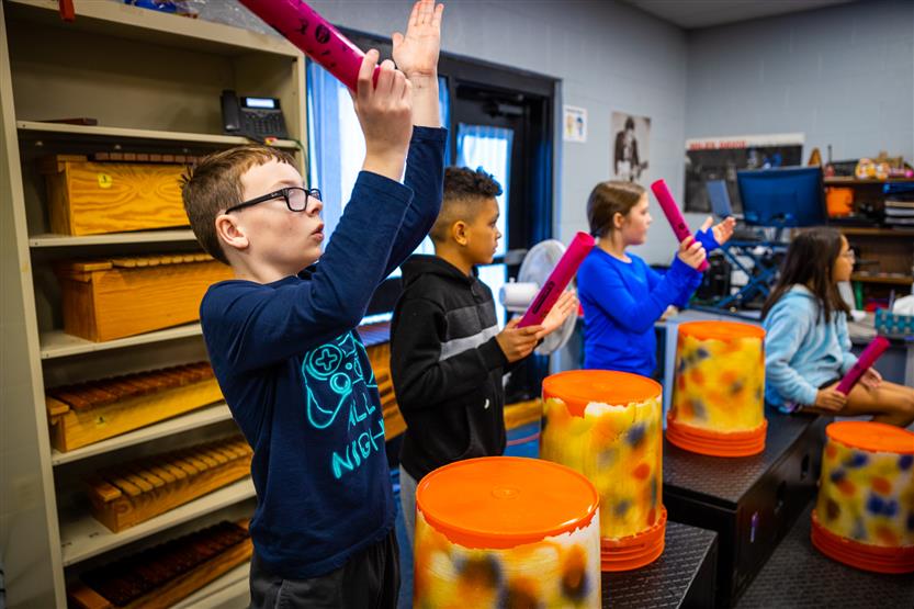 Students play drums in music class